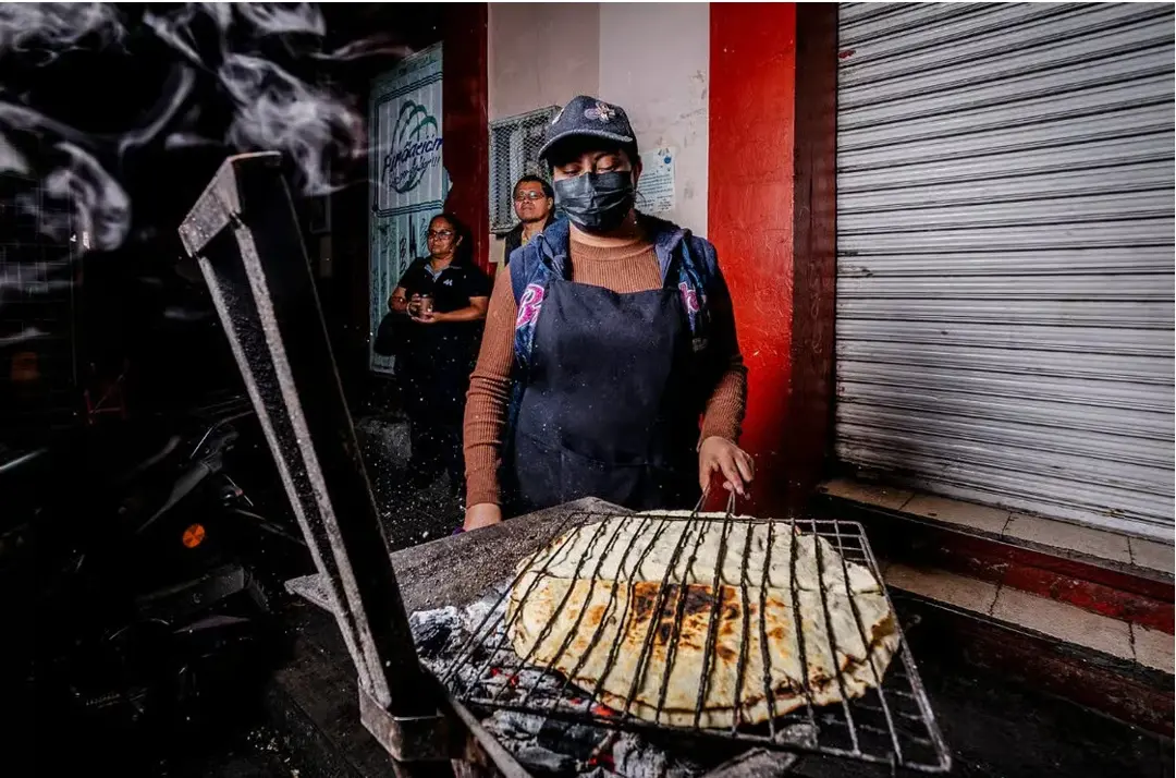 Señora preparando tlayuda en la calle. Foto: GetYourGuide Señora preparando tlayuda en la calle. Foto: GetYourGuide