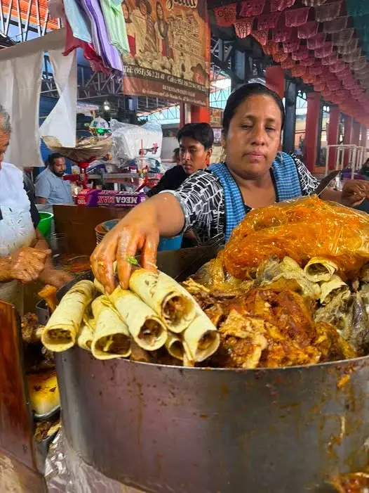 Señora sirviendo tacos de barbacoa en el mercado dominical de Tlacolula. Foto: Qué Onda Oaxaca Señora sirviendo tacos de barbacoa en el mercado dominical de Tlacolula. Foto: Qué Onda Oaxaca