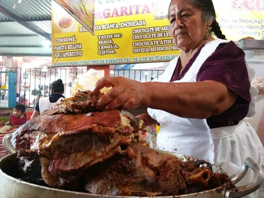 Señora mostrando barbacoa en el mercado de Tlacolula. Foto: Qué Onda Oaxaca Señora mostrando barbacoa en el mercado de Tlacolula. Foto: Qué Onda Oaxaca