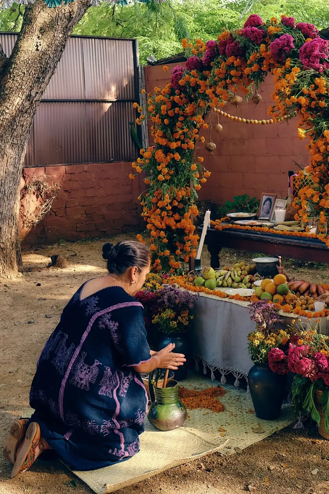 A woman preparing a traditional Día de Muertos altar in Oaxaca. Image not property of the author; used for illustrative purposes. A woman preparing a traditional Día de Muertos altar in Oaxaca. Image not property of the author; used for illustrative purposes.
