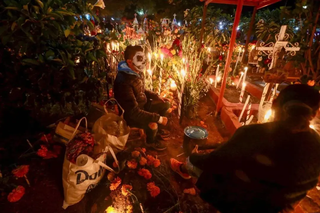 Photo by Carolina Jiménez Mariscal / Cuartoscuro. A man keeping vigil at a grave in an Oaxacan cemetery during Día de Muertos. Photo by Carolina Jiménez Mariscal / Cuartoscuro. A man keeping vigil at a grave in an Oaxacan cemetery during Día de Muertos.
